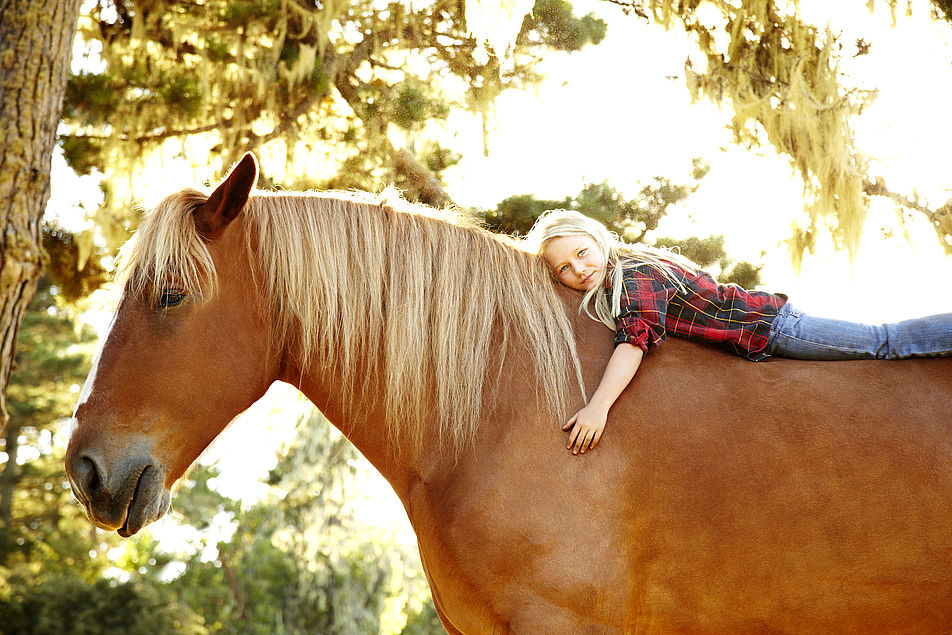 Kind auf dem Pferd.